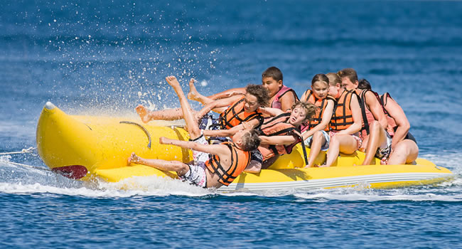 grupo de niños montando en Banana Boat en Alicante